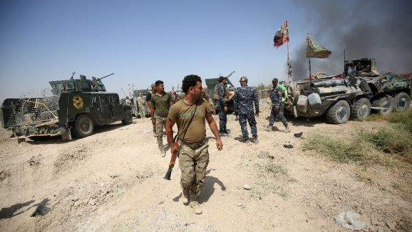 Iraqi government forces gather next to their vehicles during an operation to retake the area from Daesh on June 15, 2016 in Fallujah's southern Shuhada neighbourhood (AFP/Ahmad Al-Rubaye)