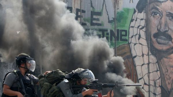 Israeli soldiers clash with Palestinian stone throwers at a checkpoint outside Jerusalem (AFP/Getty Images/ Ahmad Gharabli)