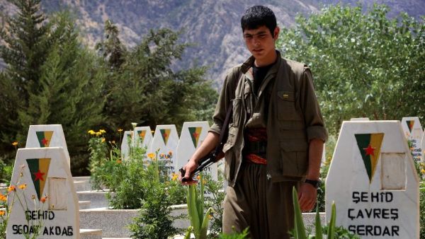 A member of the Kurdistan Workers' Party (PKK) walks past graves at a cemetary on July 29, 2015 deep in the Qandil mountain, the PKK headquarters in northern Iraq (AFP/Safin Hamed)