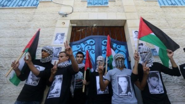 Palestinian youths wait outside the United Nations Development Programme (UNDP) offices during a 2015 rally in Gaza City. (AFP/File) 