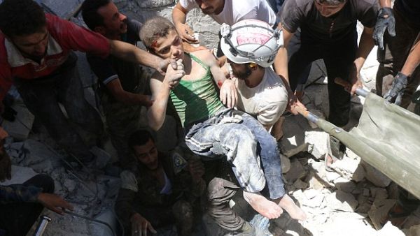 Rebel-held neighbourhoods of Aleppo have been effectively besieged by regime forces backed up by Russian air power since July 7. A boy is lifted from the rubble after an air strike. (AFP/File) 