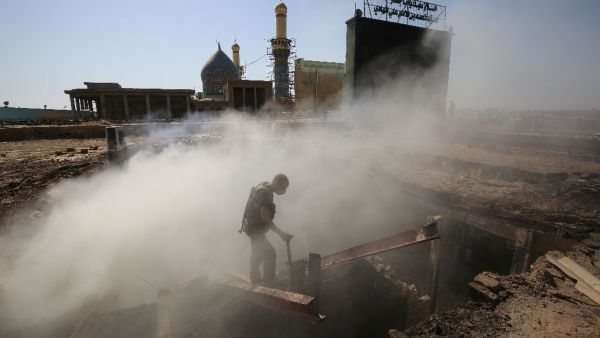 A policeman inspects the scene of a mortar and bombing attack on the Sayyid Mohammed shrine in the Balad area. (AFP/Ahmad al-Rubaye)