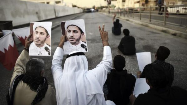 Bahrainis hold up portraits of the head of the banned Shia opposition movement al-Wefaq, Sheikh Ali Salman during clashes with riot police following a protest against his arrest on December 29, 2014 in Bilad al-Qadeem, a suburb of Manama. (AFP / Mohammed al-Shaikh)