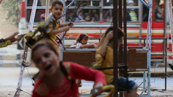 Syrian children play on swings in Arbin, on the outskirts of the capital Damascus, as they celebrate the Muslim Eid al-Adha holiday on September 13, 2016. (AFP/Amer Almohibany)
