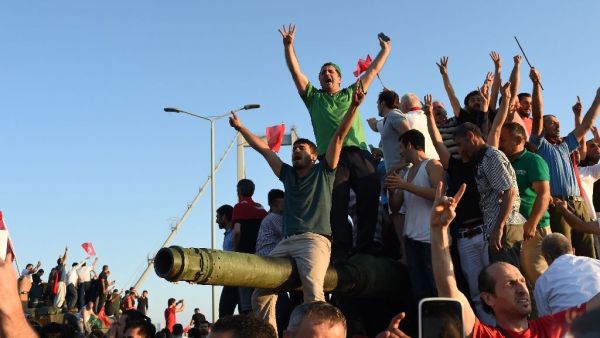 People react after taking over military position on the Bosphorus bridge in Istanbul, on July 16, 2016 (AFP/Bulent Kilic)