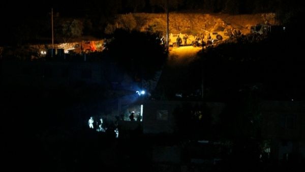 Israeli soldiers wait next to their vehicles in the West Bank village of Dura near Hebron on August 30, 2016. (AFP/Hazem Bader) 