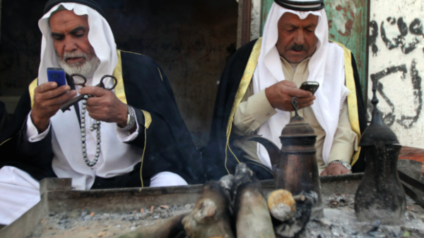 Two elderly Palestinian refugees hold mobile phones along with their traditional house keys in Gaza. (AFP/File)