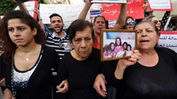 The mother of Roula Yacoub, a victim of domestic violence, holds a portrait of her deceased daughter during a rally on "International Women's Day" on March 8, 2014 in front of the National Museum in Beirut, Lebanon. (AFP/File)