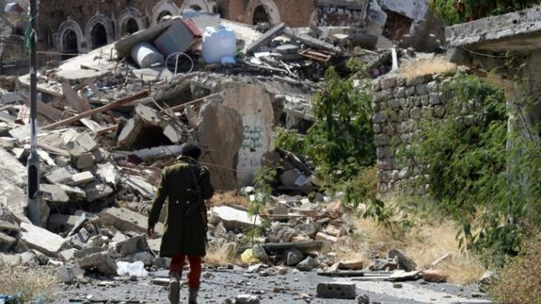 A Yemeni man inspects the damage on a street following clashes on November 22, 2016 in Taez. (AFP/Ahmad Al Bashar)