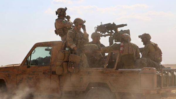 Armed men in uniform identified by Syrian Democratic Forces as US special operations personnel ride in a pickup truck in the village of Fatisah in the northern Syrian province of Raqa on May 25, 2016. (AFP/Delil Souleiman)