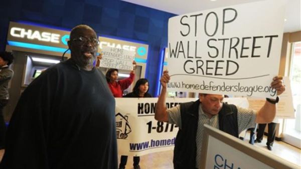 أمريكيون مهددون بالطرد من بيوتهم يتظاهرون أمام مكتب تابع لأحد البنوك.