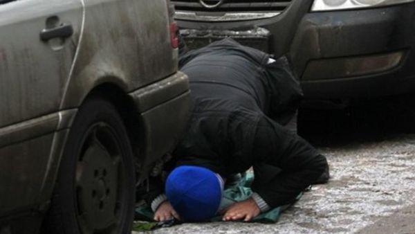 رجل مسلم يصلي في الشارع.