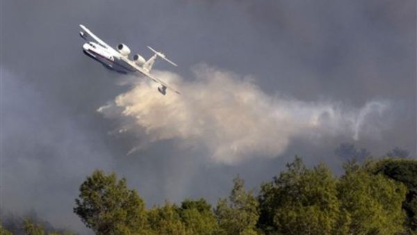 طائرة روسية ترش حمولتها من الماء على ألسنة اللهب المتصاعدة من حرائق جبل الكرمل في إسرائيل.
