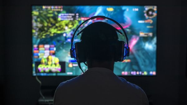 Young gamer playing video game wearing headphone (Shutterstock/File Photo)