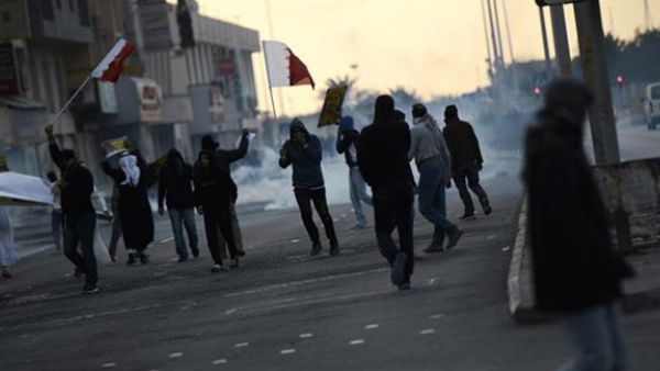 Bahraini protesters run for cover from tear gas during clashes with police in the village of Sitra, south of the capital Manama, on January 29, 2016. (AFP)