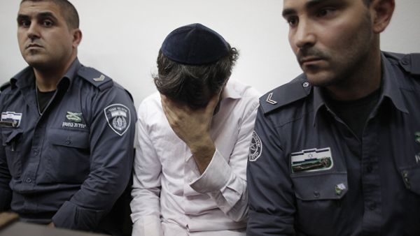 Police escort Yosef Haim Ben-David, one of the Jewish suspects of the murder of Muhammed Abu Khdeir, in the Disctrict Court in Jerusalem. (AFP/Ahmad Gharabli)
