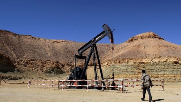 A Libyan security member walks past an oil drill on the Al-Ghani oil field near the city of Waddan on March 23, 2013. (AFP)