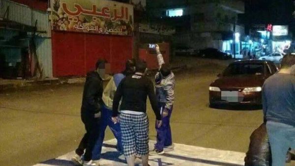 A group of youths take a selfie while standing on an Israeli flag in the northern Jordanian city of Irbid. (Twitter)