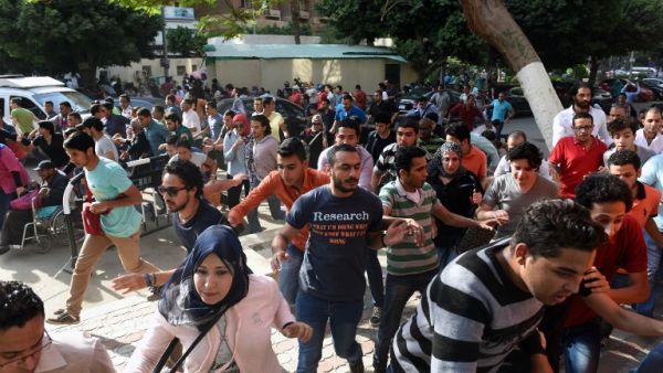 Protesters run from tear gas in Cairo on April 25. (AFP/Mohamed El-Shahed)