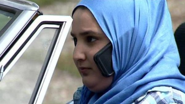A women uses her phone while driving "hands-free" in her hijab. (Twitter)
