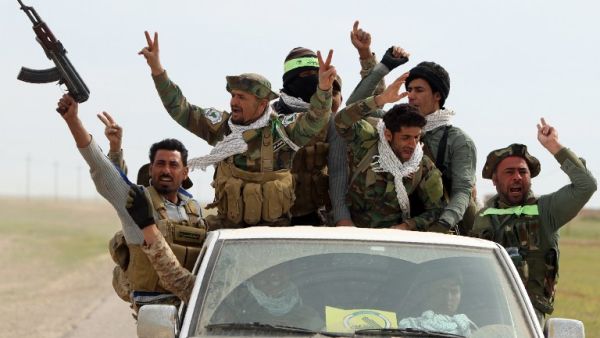 Iraqi Shia fighters from the Popular Mobilization units sit in the back of a vehicle as they drive down a road, in the desert of Samarra, on March 3, 2016, during an operation aimed at retaking areas from Daesh. (AFP/Ahmad al-Rubaye)