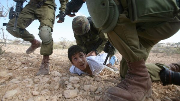 A Palestinian youth is arrested by Israeli soldiers for throwing stones during a protest. (AFP/Hazem Bader)