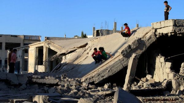 Children play on the rubble of a destroyed building in the rebel-held city of Daraa, Syria. (AFP/Mohamad Abazeed)