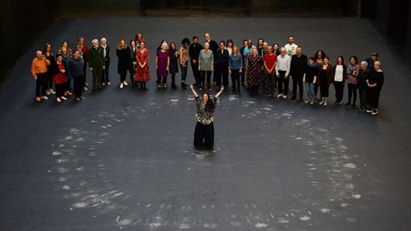 Tania Bruguera, centre, and guests stand after lying on her artwork, a heat-sensitive floor, in the Turbine Hall at the Tate Modern (Twitter)