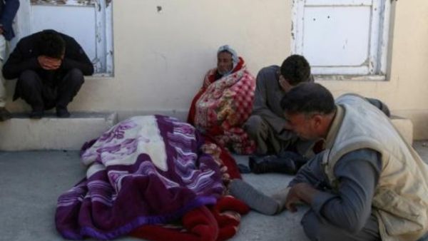 رجال أفغان متشددون قرب جثة في موقع هجوم شنه مسلحو طالبان على مجمع حكومي في منطقة خواجة العمري في إقليم غزنه الجنوبي الشرقي
