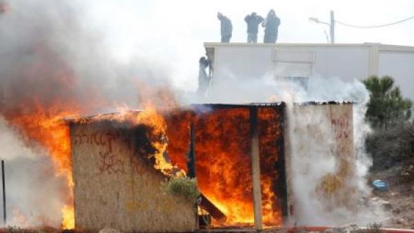 محتجون يقفون فوق سطح أحد المباني خلال طرد الشرطة الإسرائيلية مستوطنين من بؤرة عمونا الاستيطانية
