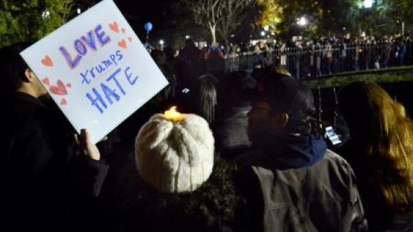 متظاهرة تحمل لافتة مكتوب عليها "الحب يغلب الكراهية" خلال وقفة بالشموع احتجاجا على انتخاب الرئيس الأمريكي المنتخب دونالد ترامب بالقرب من البيت الأبيض في واشنطن
