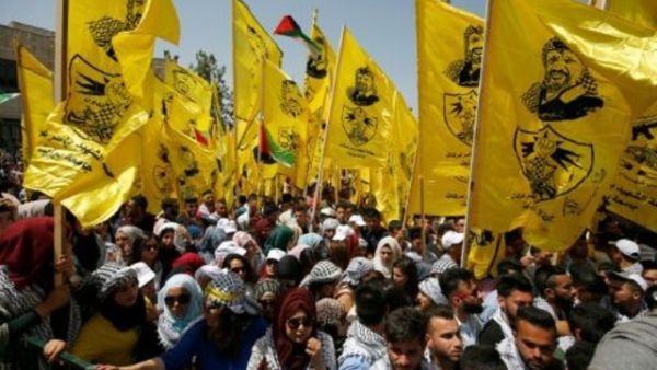 طلاب فلسطينيون مؤيدون لحركة فتح يرفعون اعلاما تحمل صورة الزعيم الراحل ياسر عرفات في تجمع انتخابي طلابي بجامعة بيرزيت قرب رام الله

