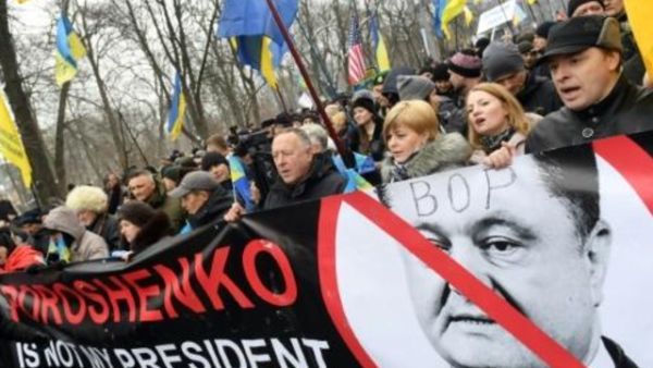 محتجون يحملون لافتة عليها صورة الرئيس الاوكراني بترو بوروشنكو وقد كتب عليها "بوروشنكو ليس رئيسي" في احتجاج نظم دعما للرئيس الجورجي السابق ميخائيل ساكاشفيلي في كييف
