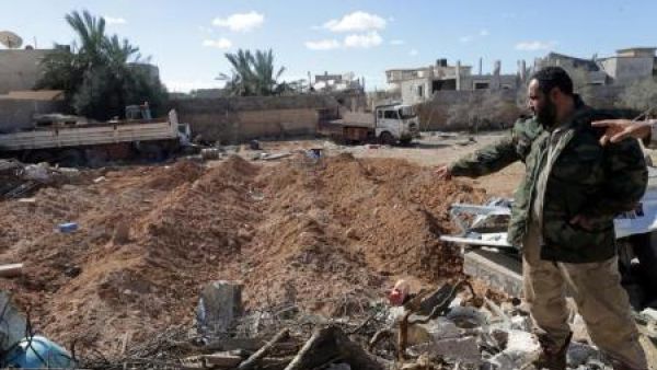 أحد عناصر القوات الليبية يتفقد موقعا قصفته طائرة أمريكية في احدى ضواحي بنغازي

