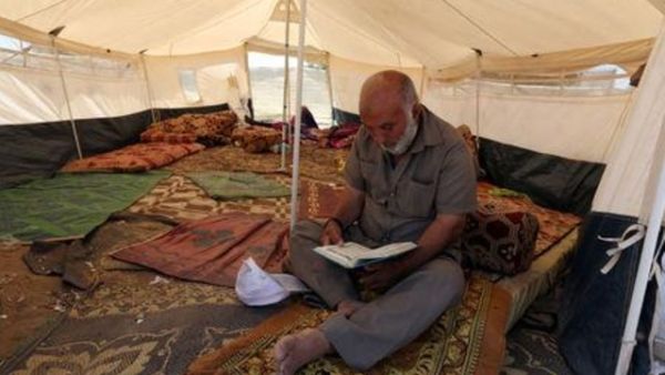 رجل فلسطيني يقرأ القرآن داخل خيمة خلال شهر رمضان في مخيم احتجاج قرب حدود إسرائيل مع قطاع غزة
