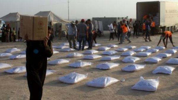 عراقية تحمل علبة مساعدات من الصليب الاحمر في الانبار
