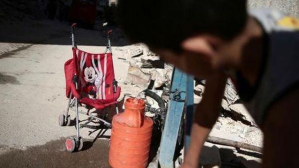صبي يملأ وعاء بالماء في إحدى ضواحي دمشق
