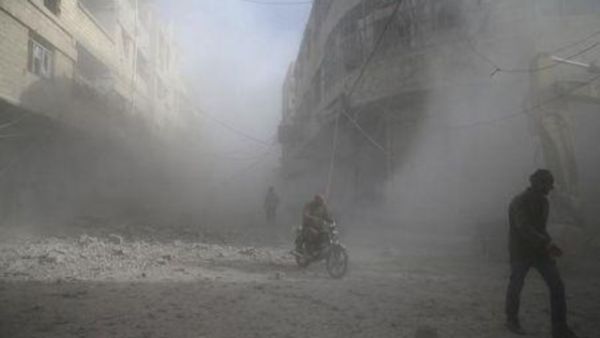 أناس أثناء قصف بلدة في الغوطة الشرقية في ريف دمشق بسوريا
