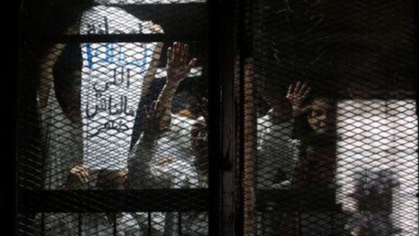 المصور المصري محمود ابو زيد (يمينا) مع صحفيين آخرين اثناء احدى جلسات محاكمتهم

