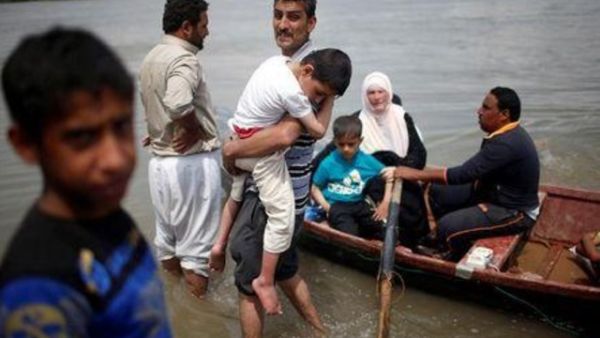 نازحون عراقيون يستعدون لعبور نهر دجلة في قارب بعد أغلاق جسر بشكل مؤقت في غرب الموصل
