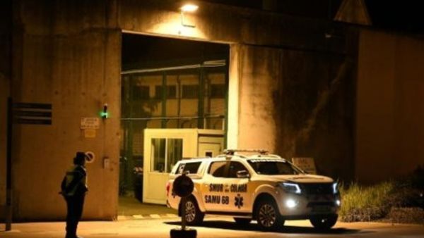 دركي فرنسي يقف بالقرب من سيارة تابعة لدائرة الخدمات الطبية الطارئة "سامو" أمام سجن إنزيسايم في شرق فرنسا

