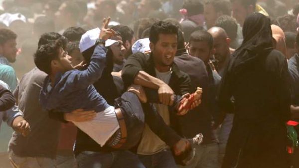 فلسطينيون يحملون جريحا اصيب برصاص القوات الاسرائيلية على حدود غزة