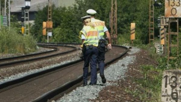 شرطيان يتفقدان خط سكك الحديد في فورتسبورغ غداة عملية الاعتداء بفأس على متن قطار

