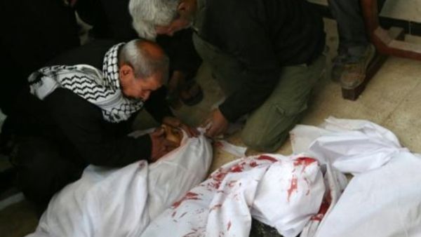 اب سوري في مدينة عربين في الغوطة الشرقية يبكي ابنه الذي قتل في قصف جوي استهدف هذه المدينة
