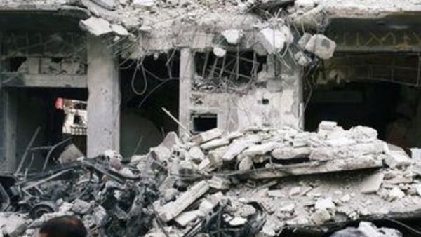 رجلان يسيران وسط مبان دمرت في بلدة دوما المحاصرة في الغوطة الشرقية 
