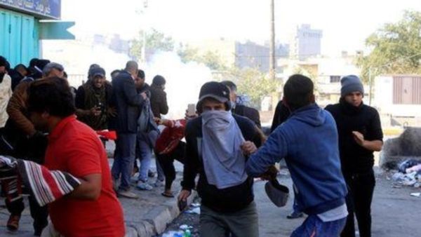 قوات الأمن العراقية تطلق الغاز المسيل للدموع على محتجين من أنصار الزعيم الشيعي مقتدى الصدر بالقرب من المنطقة الخضراء في بغداد يوم السبت

