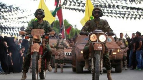 أفراد من حزب الله اللبناني يستقل دراجات نارية ومركبات خلال عرض في قرية بجنوب لبنان
