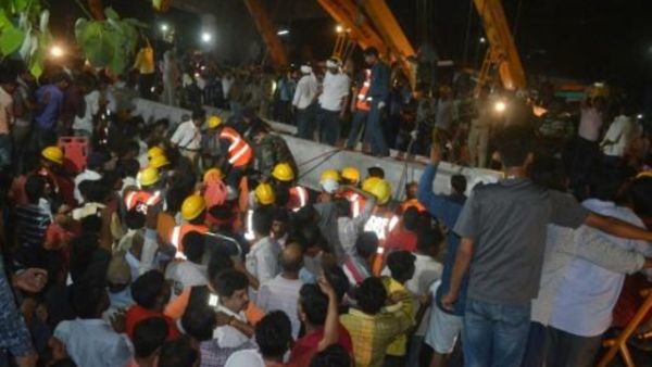 عاملو إغاثة ومارة يتجمعون حول موقع انهيار جسر في مدينة فاراناسي في ولاية اوتار براديش في شمال الهند
