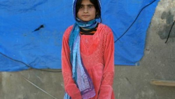 فتاة عراقية من طائفة الشبك تقف قرب منزلها الذي دمره جهاديو تنظيم الدولة الاسالمية في شرق الموصل
