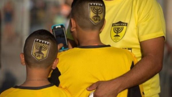 انصار نادي بيتار القدس ويبدو شعار النادي مرسوما على راسهم
